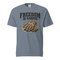 blue men's t-shirt with work gloves on a wooden surface, and above it says "Freedom is earned"