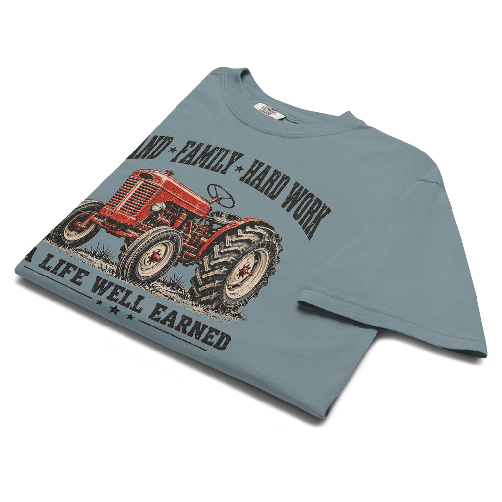 men's blue t-shirt with vintage red tractor graphic, and the words "land family hard work, a life well earned" written above and below