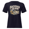 navy women's shirt with a wildflower graphic and dirt road below the text "backroad bloom"