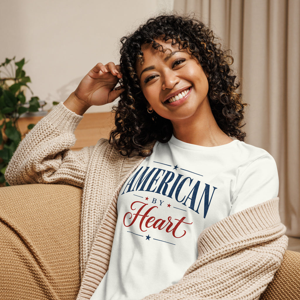 women's white t-shirt with lettering that says "American by Heart and small red and blue star accents